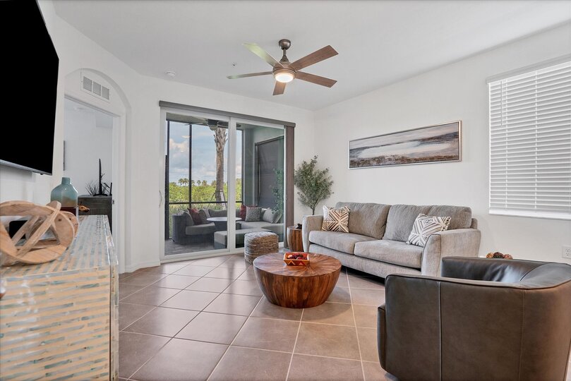 Bright, open living space overlooking pond and nature preserve. Living room features comfy seating and 55-inch Smart TV
