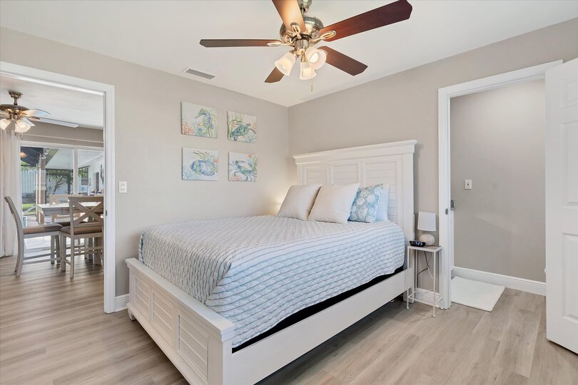 Guest bedroom 1 with queen bed and attached half bathroom