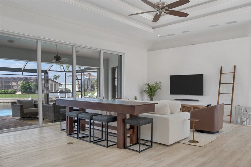 Gorgeous open living area with ample seating, 65-inch Smart TV & dining table that converts to a tavern shuffleboard table