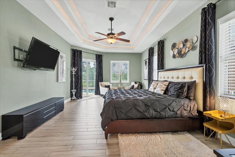 Large primary bedroom with king bed, en suite, lanai access, and  55-inch Roku TV