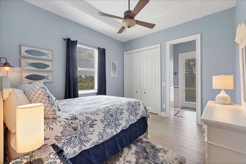 Guest bedroom 1 features one queen bed, attached bathroom with lanai access