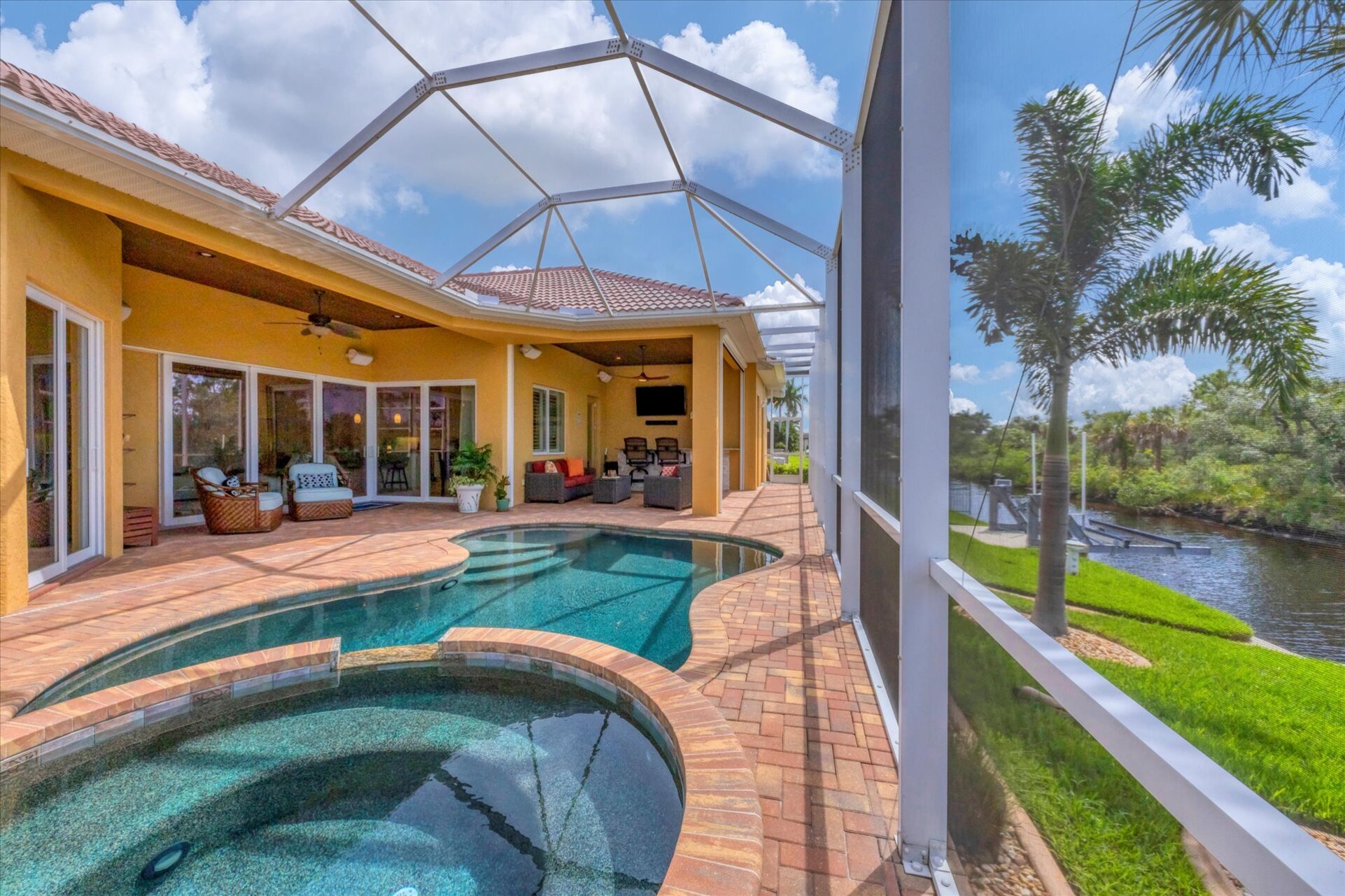 Large outdoor living space overlooking canal and nature preserve. Lanai features ample seating, outdoor kitchen, bar, 65-inch Smart TV, sparkling private pool & spa, and remote controlled privacy screens. Pool size is 17'L x 10'W x 6'D