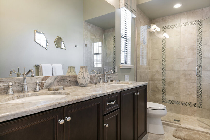 En-suite bathroom with granite dual vanity and glass walk-in shower