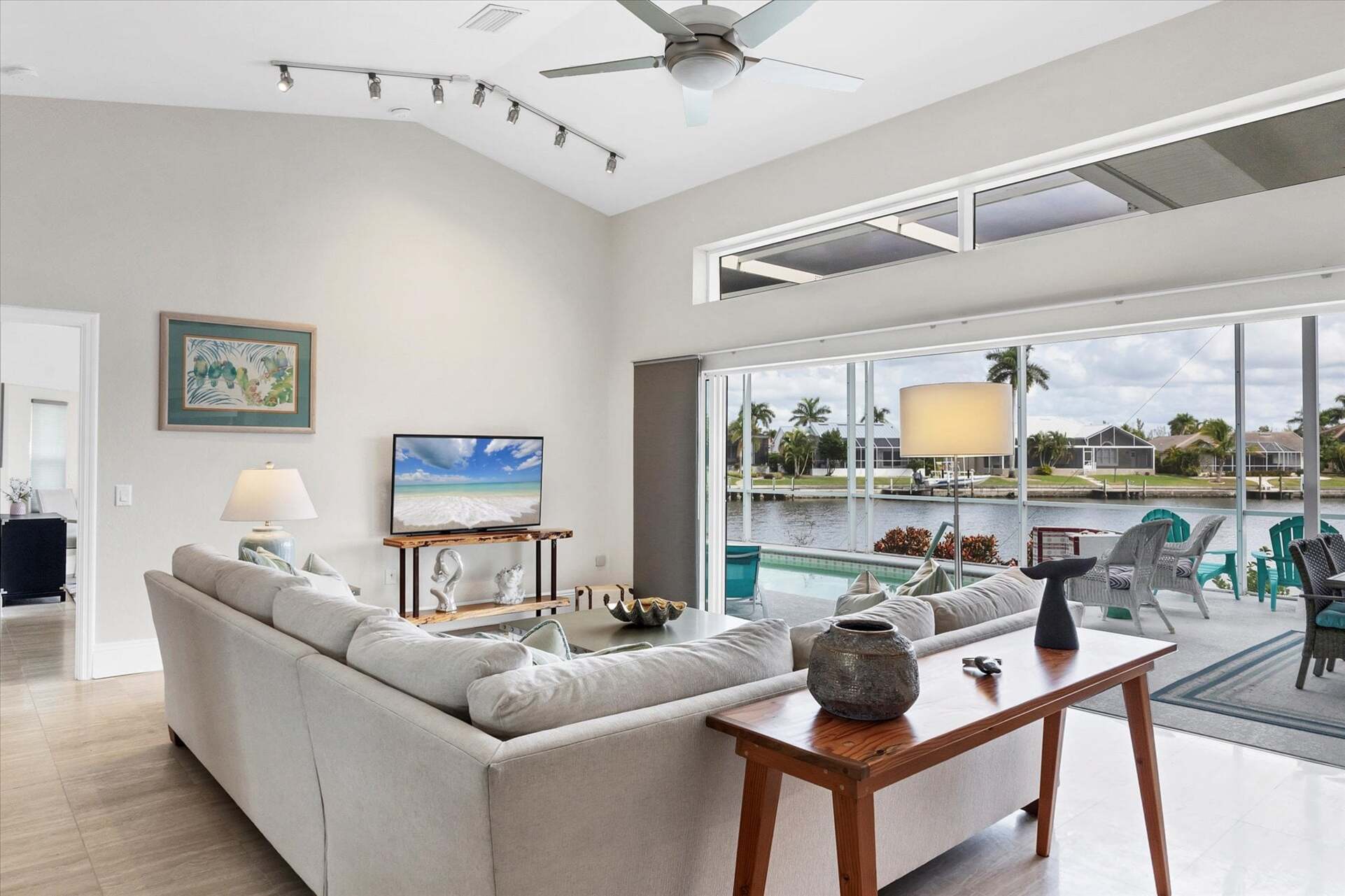 Family room overlooking sparkling pool and canal beyond. Features comfy seating and a 56-inch Smart TV