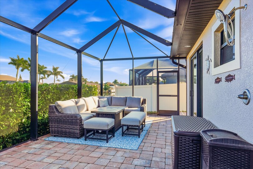 Large outdoor living area overlooking the sparkling pool and canal. Great for entertaining. Features a dining table that seats 6, BBQ grill, outdoor kitchen, Conversation furnite set, and 43" Smart TV