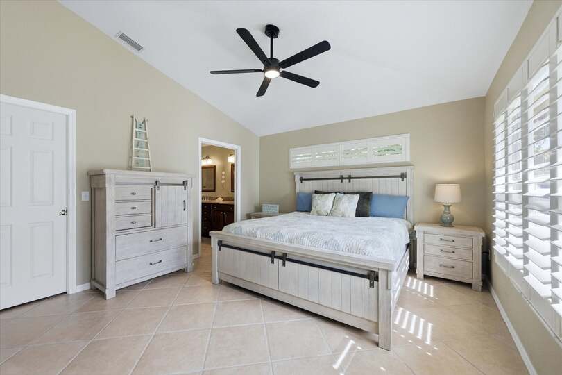 Primary bedroom with king bed, attached bathroom, and 46-inch smart TV
