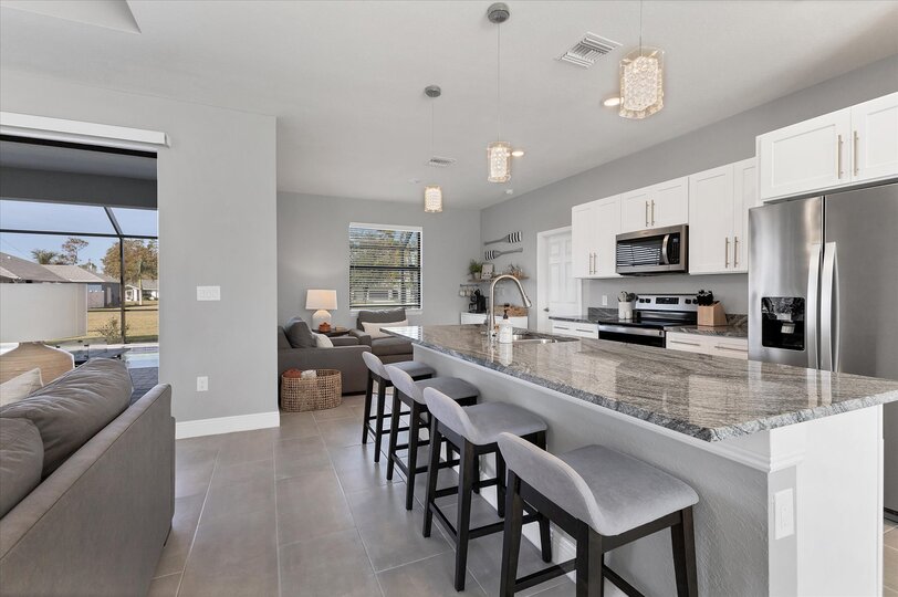 Fully equipped kitchen overlooking living room and dining area. Kitchen island seats 4