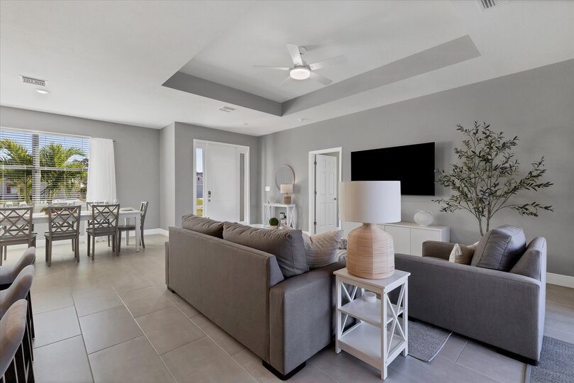 Living room overlooks the pool and features comfy seating and a 55" Smart TV