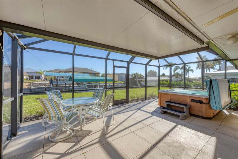 Screened-in patio overlooking the canal with private hot tub that seats 6