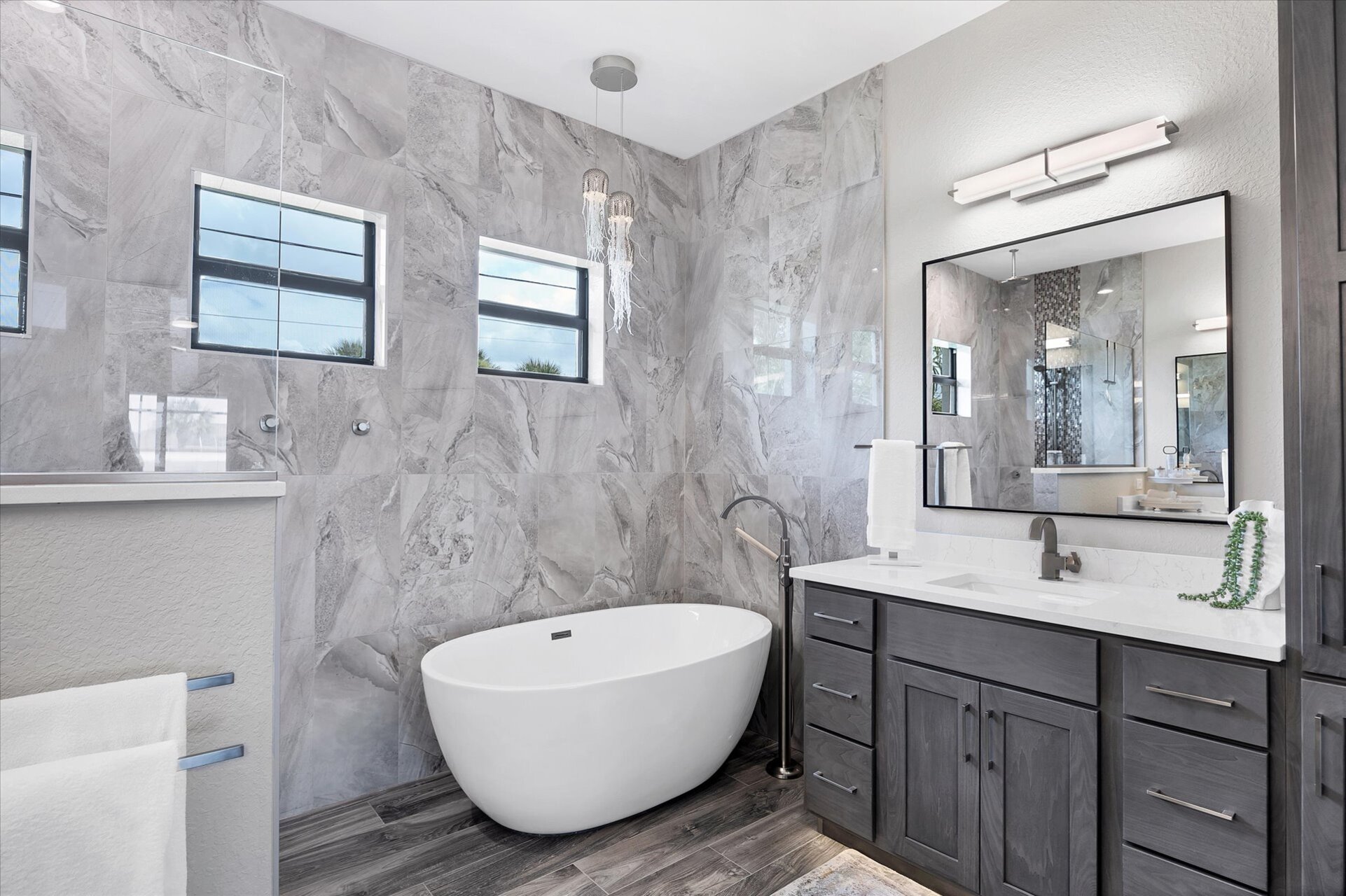 Primary bedroom's attached bathroom with large walk-in shower, double vanities and a relaxing soaking tub