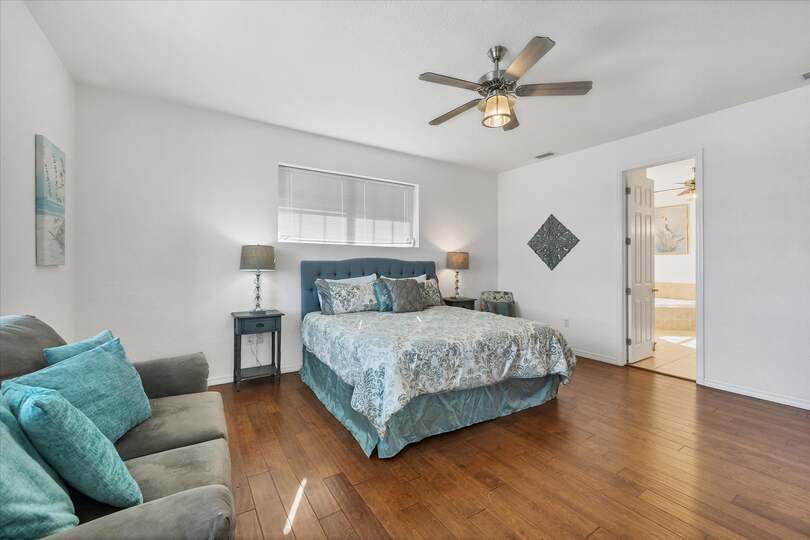 Upstairs primary suite with balcony access, king bed bed and attached bathroom