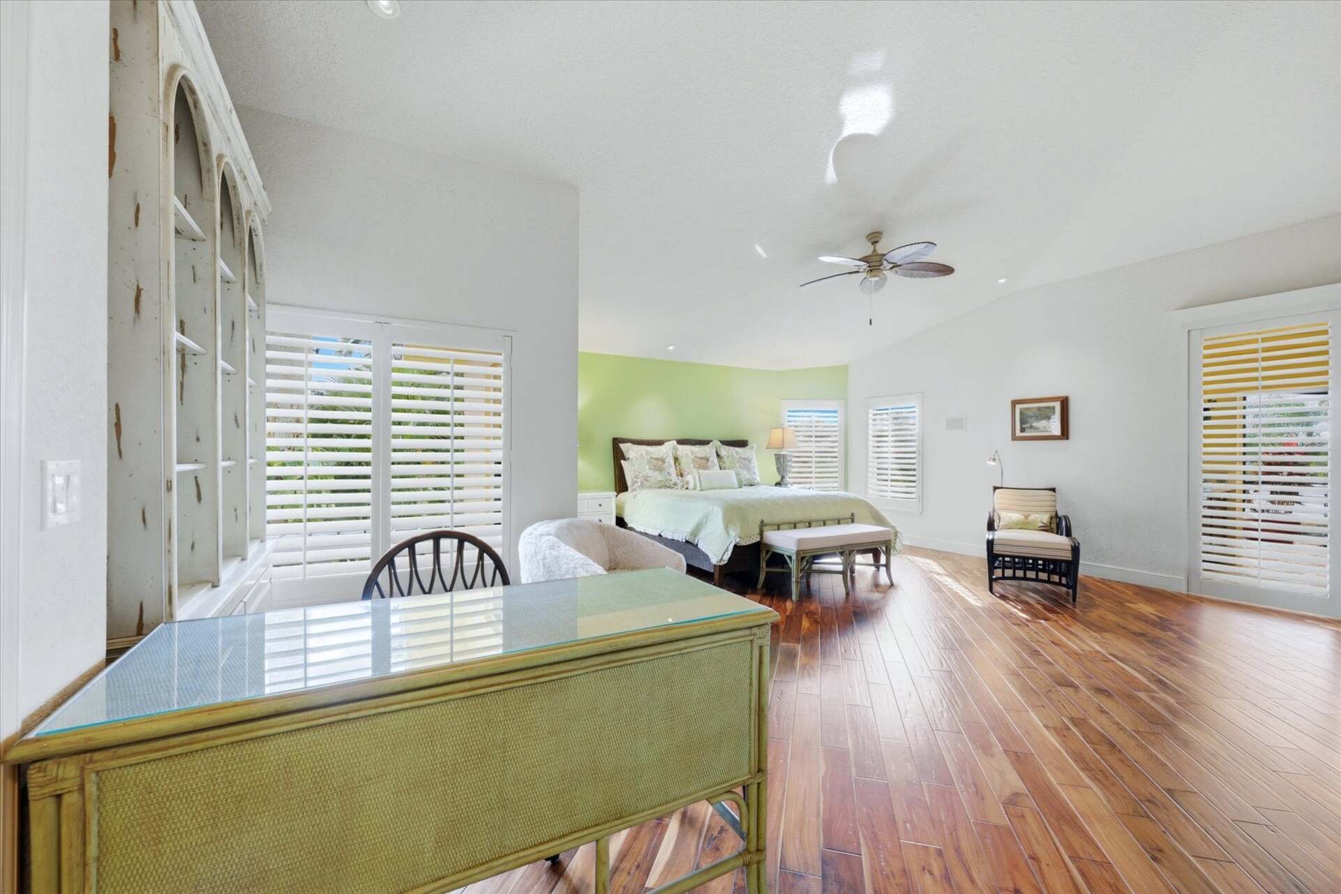 Huge primary bedroom with king bed, lanai acces, attached bathroom, desk & chair, and 55-inch Smart TV