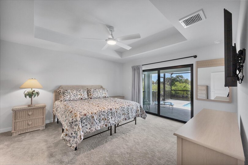 Primary bedroom with king bed, lanai access, en suite, and 55-inch Smart TV